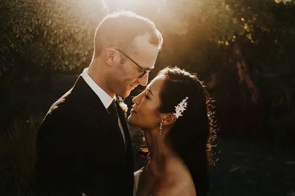 Couple embracing in warm evening light on their wedding day.